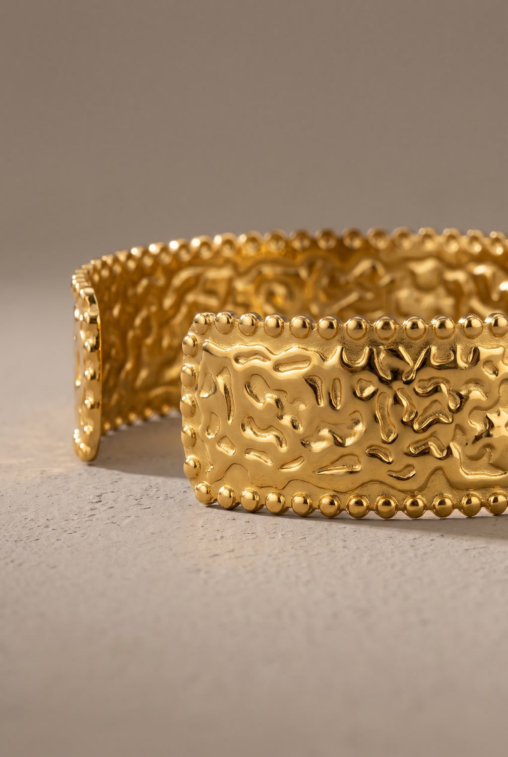 Close-up of the hammered texture and beaded edges of the gold cuff