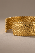 Close-up of the hammered texture and beaded edges of the gold cuff