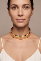 Plain polished torque collar in gold worn on the neck
